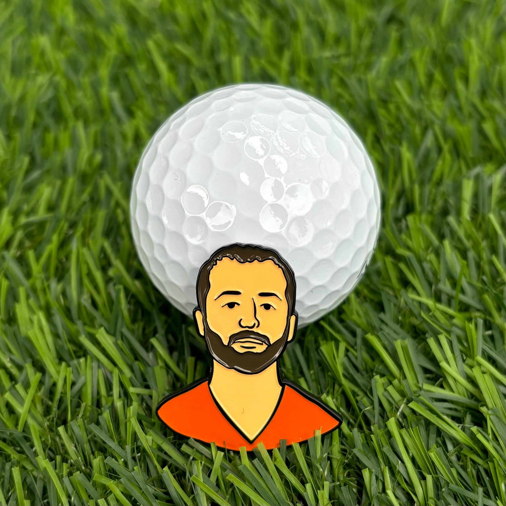 Prison Scotty Golf Ball Marker on grass with a golf ball in the background